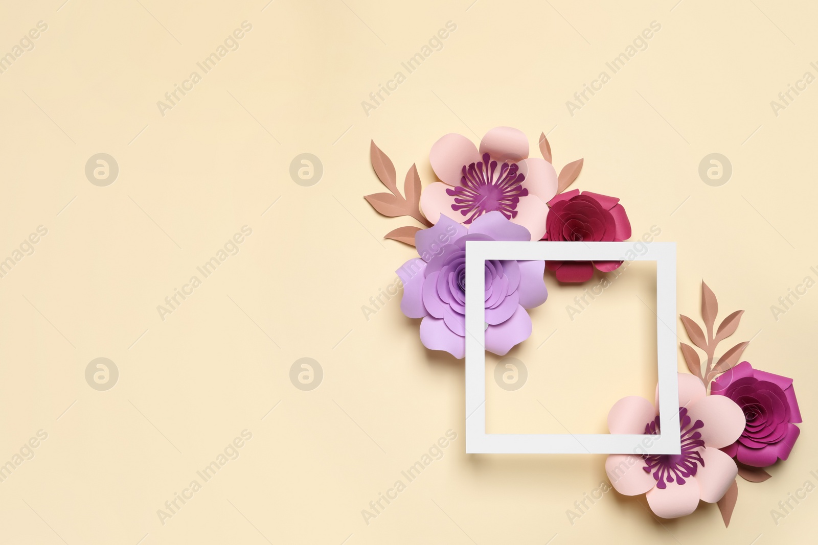 Photo of Different beautiful flowers made of paper and frame on beige background, flat lay. Space for text