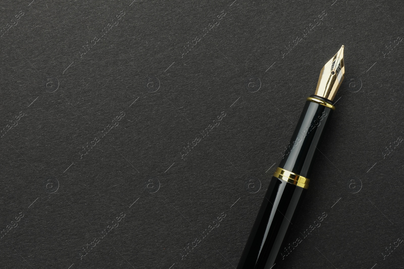 Photo of Stylish fountain pen on black background, top view. Space for text