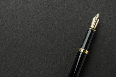 Photo of Stylish fountain pen on black background, top view. Space for text