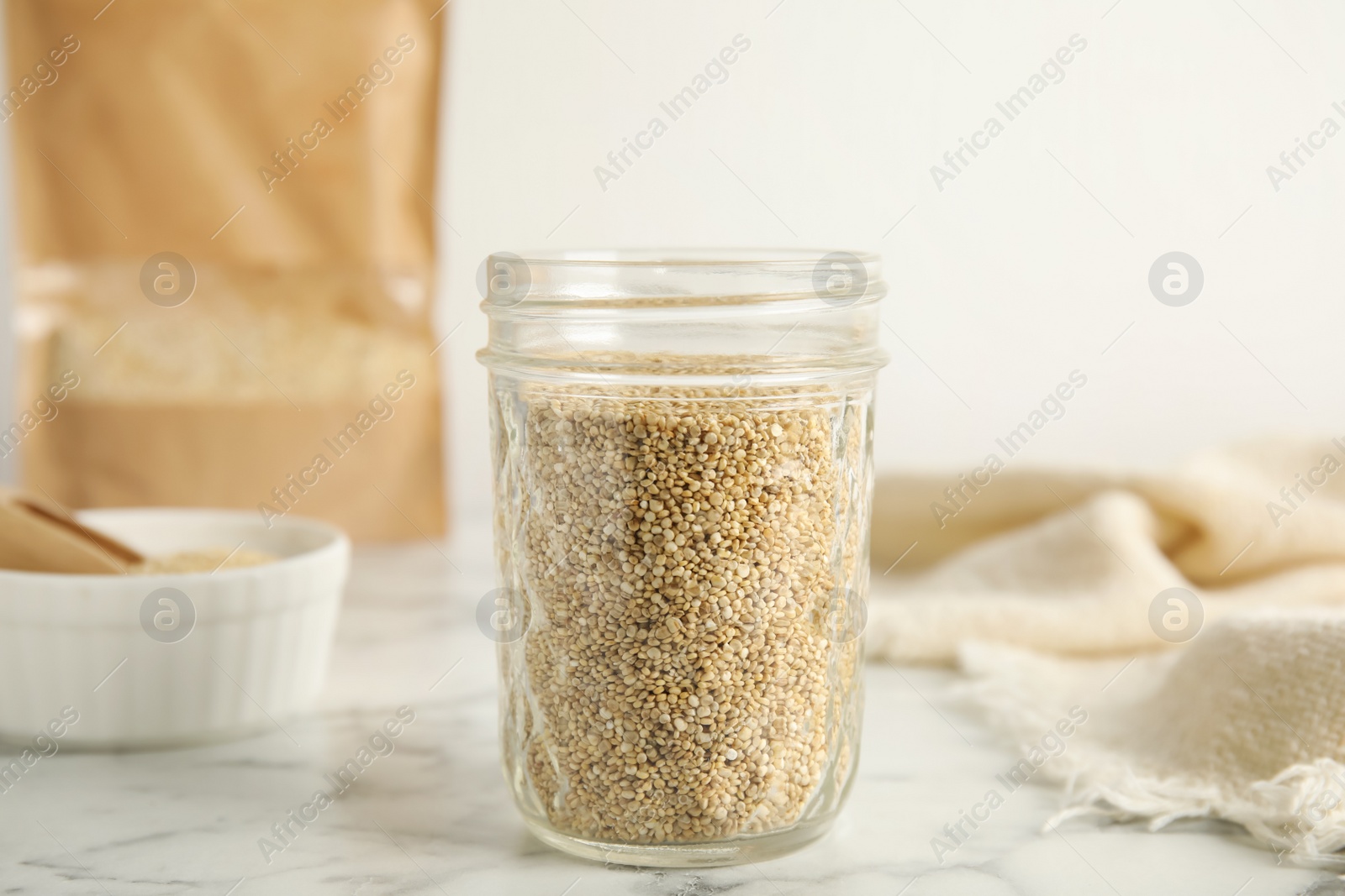 Photo of Jar with white quinoa on marble table