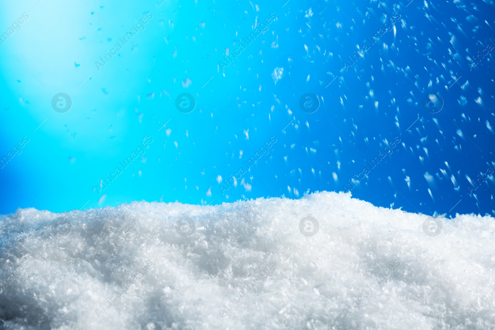 Photo of Snow flakes falling on blue background. Winter weather