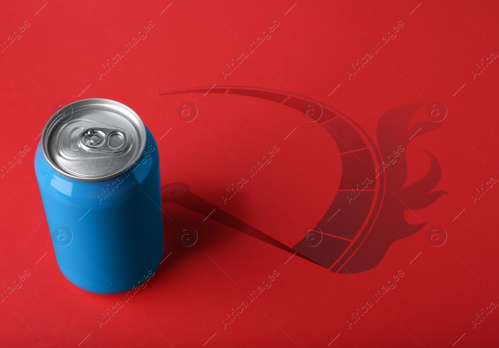 Image of Energy drink and shadow in shape of speedometer with fire on red background 