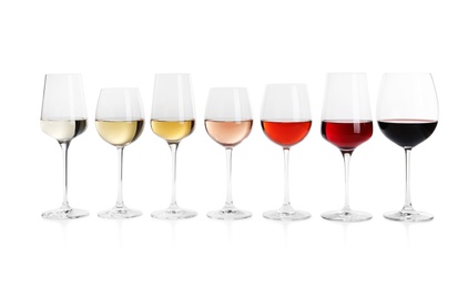 Photo of Row of glasses with different wines on white background