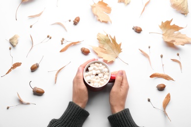Photo of Woman holding hot drink on white background, top view. Cozy autumn