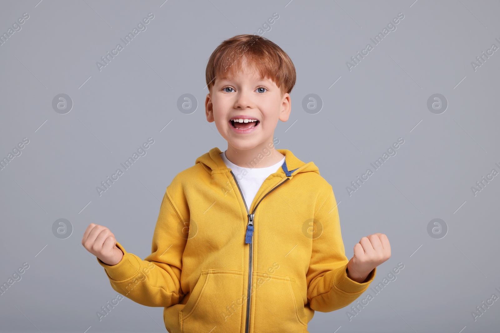 Photo of Portrait of surprised little boy on grey background