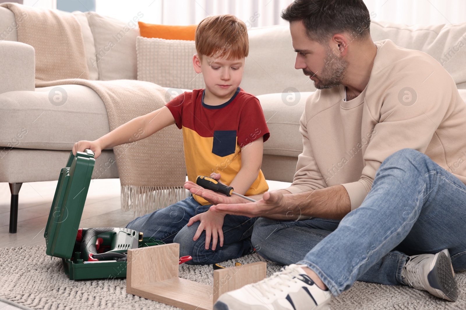 Photo of Father and son repairing shelf together at home