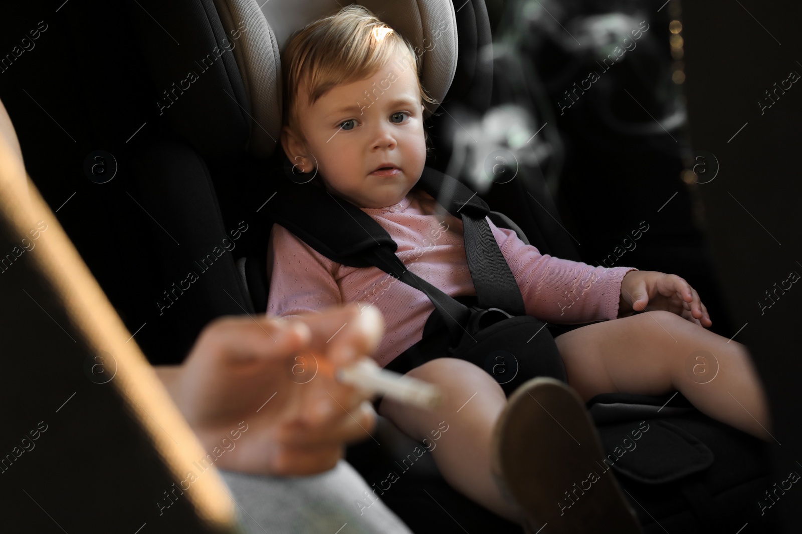 Photo of Mother with cigarette and child in car, closeup. Don't smoke near kids