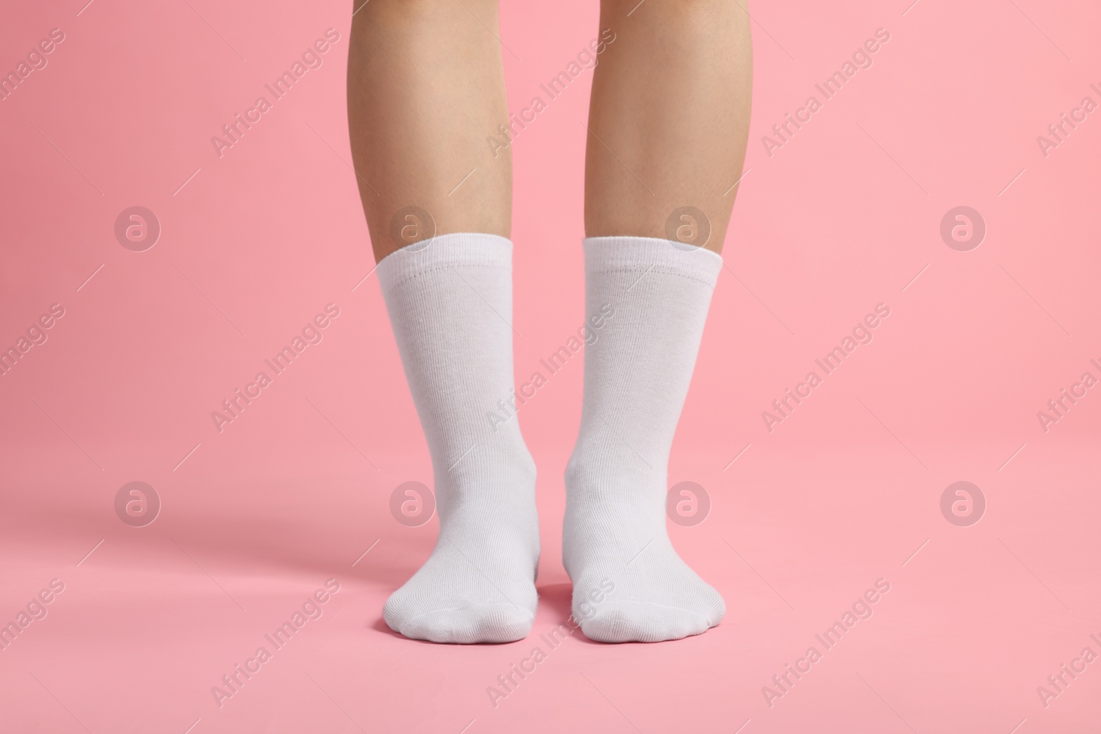 Photo of Woman in stylish white socks on pink background, closeup