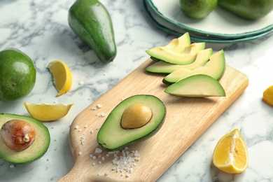 Composition with ripe avocados and lemon on table