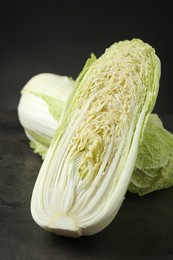 Photo of Whole and cut fresh Chinese cabbages on grey table