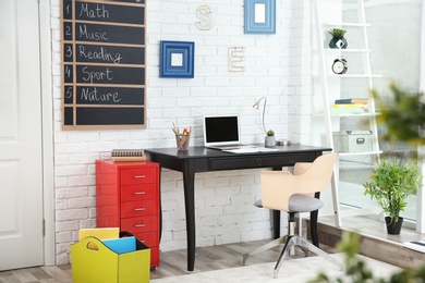 Modern child room interior with desk and laptop