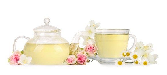 Aromatic herbal tea in glass cup, teapot and flowers isolated on white