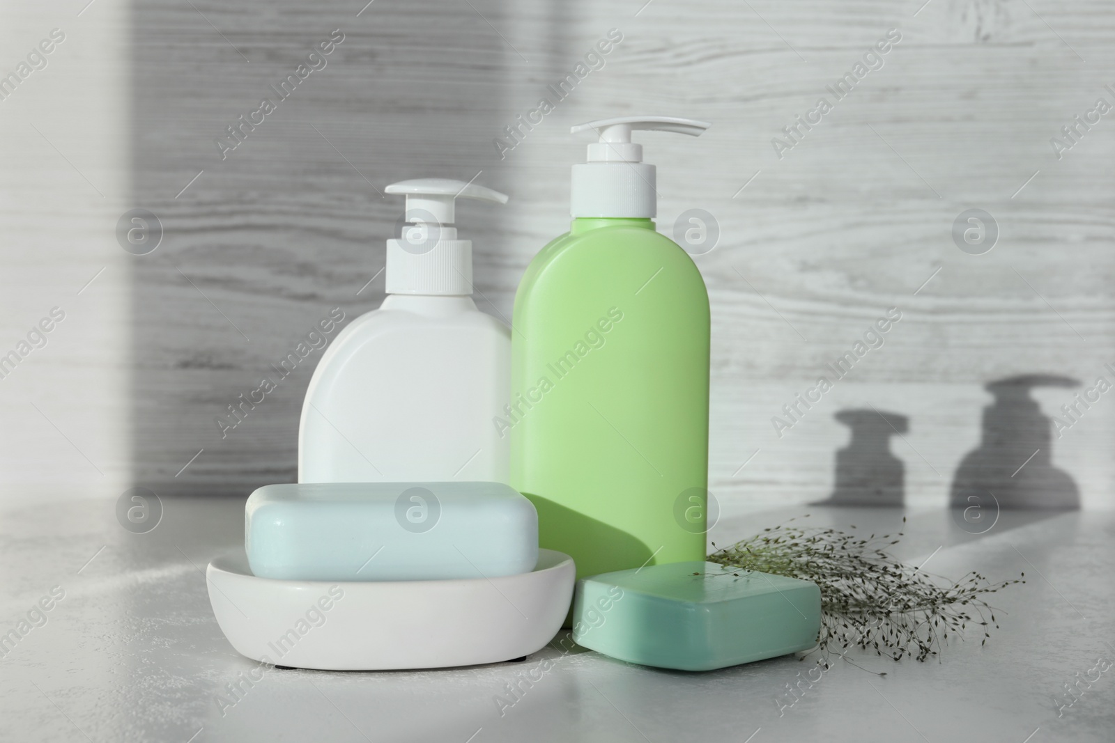 Photo of Soap bars and bottle dispensers on white table