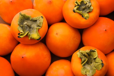 Photo of Delicious ripe juicy persimmons as background, top view