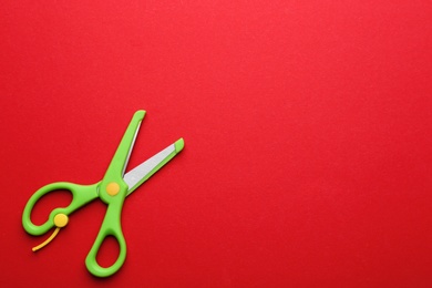 Training scissors on color background, top view. Space for text