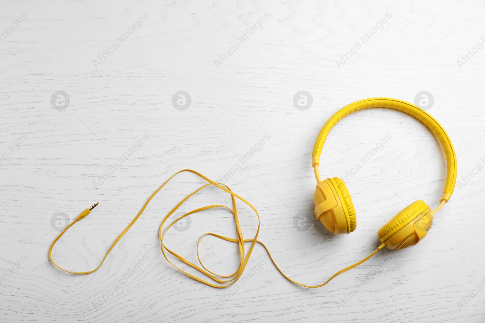 Photo of Stylish modern headphones and space for text on wooden background, top view