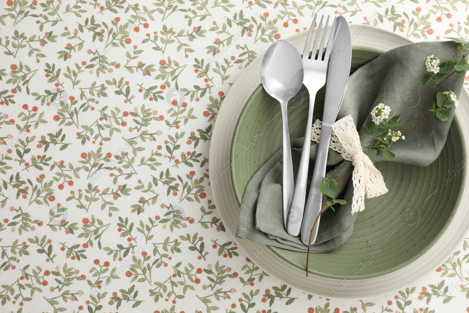 Photo of Stylish setting with cutlery, plates, napkin and floral decor on table, top view. Space for text