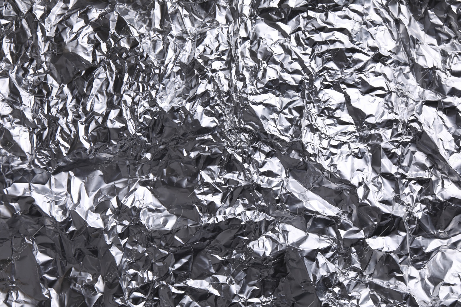 Photo of Crumpled silver foil as background, closeup view