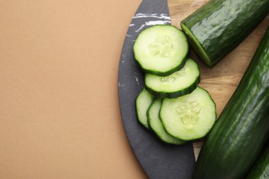 Fresh cucumbers on beige background, top view. Space for text