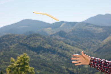Photo of Man throwing boomerang in mountains, closeup view