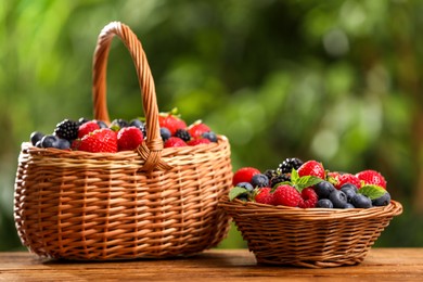 Photo of Different fresh ripe berries on wooden table outdoors