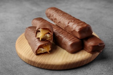 Sweet tasty chocolate bars with caramel on grey table