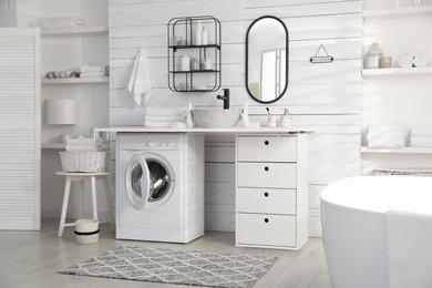 Stylish bathroom interior with modern washing machine