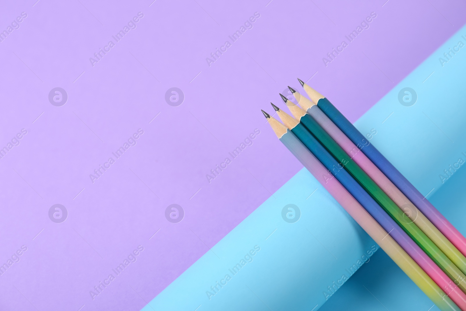 Photo of Pencils and rolled paper on color background. Space for text