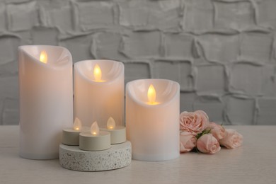 Decorative LED candles on white wooden table