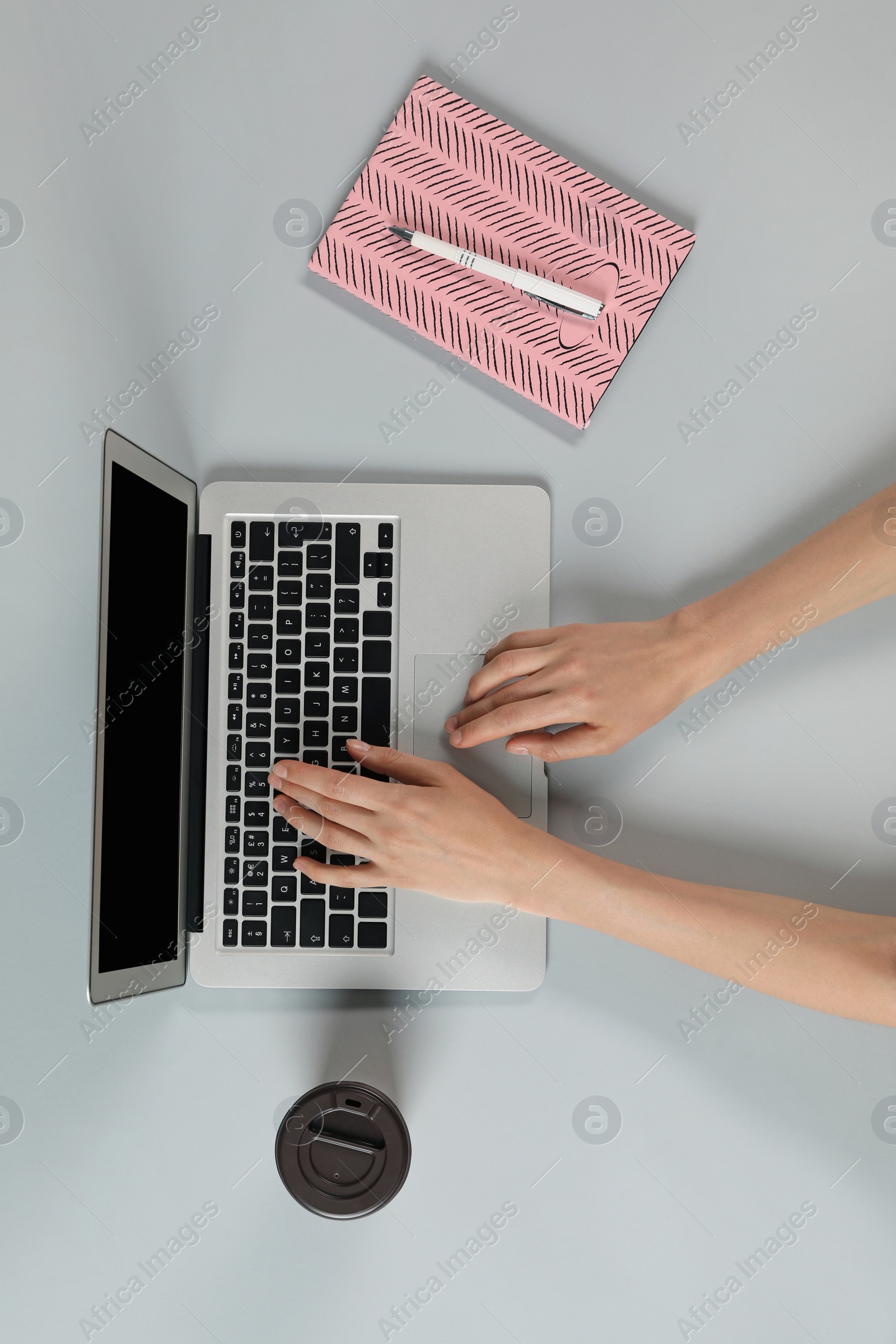 Photo of Woman using modern laptop at table, top view