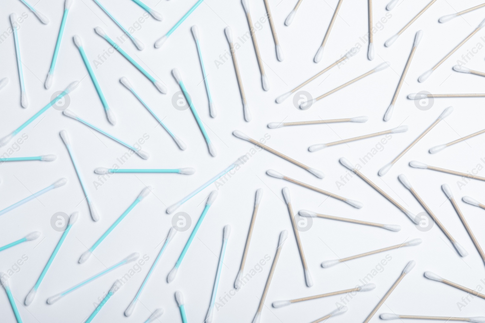 Photo of Plastic and wooden cotton swabs on white background, top view. Recycling concept