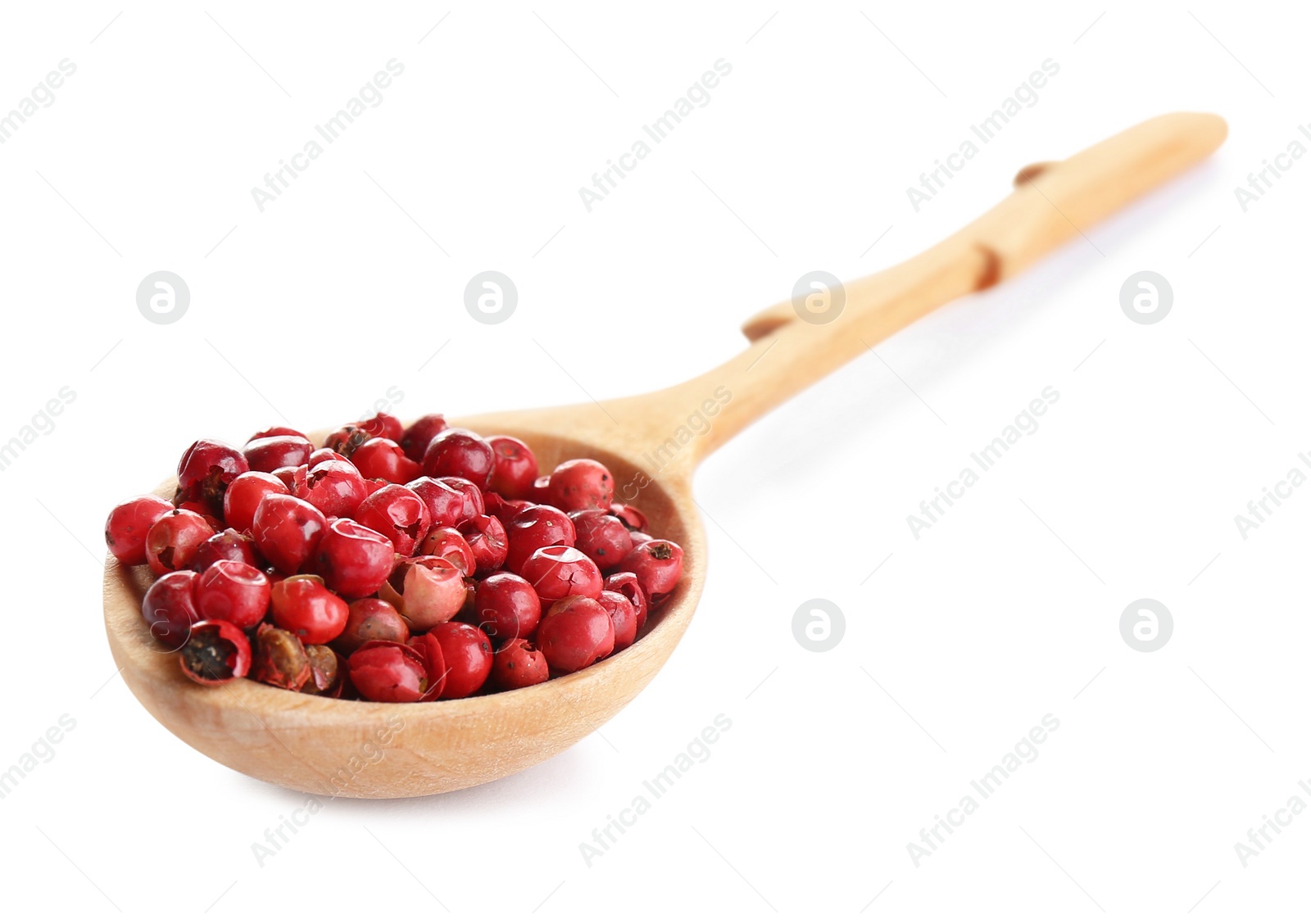 Photo of Spoon of red peppercorns isolated on white