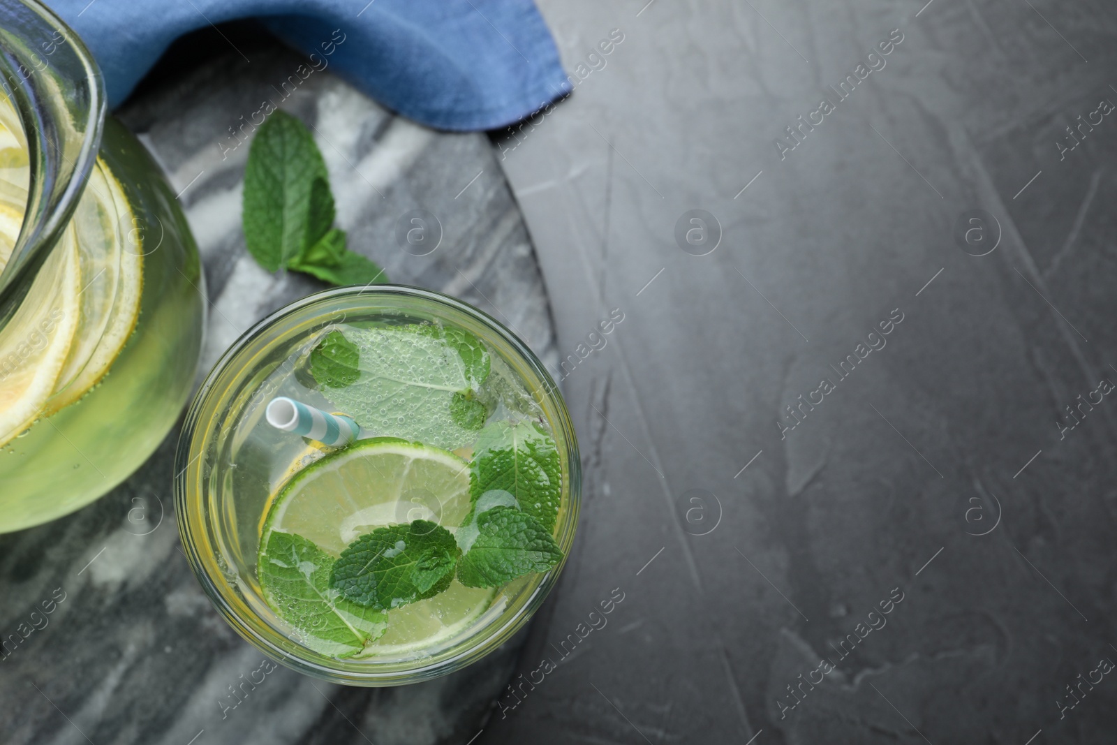 Photo of Delicious lemonade made with soda water and fresh mint on grey table, flat lay. Space for text