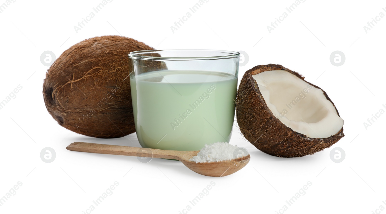 Photo of Glass of delicious coconut milk, spoon with flakes and nuts on white background