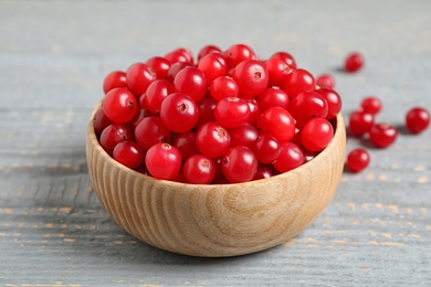 Photo of Tasty ripe cranberries on grey wooden table, closeup