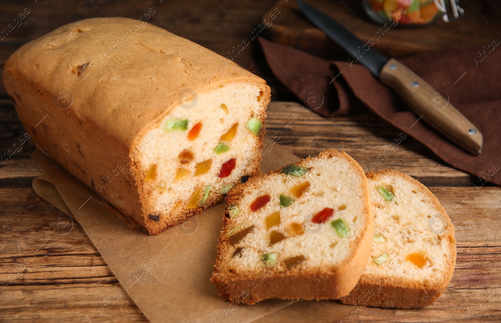 Photo of Delicious cake with candied fruits on wooden table