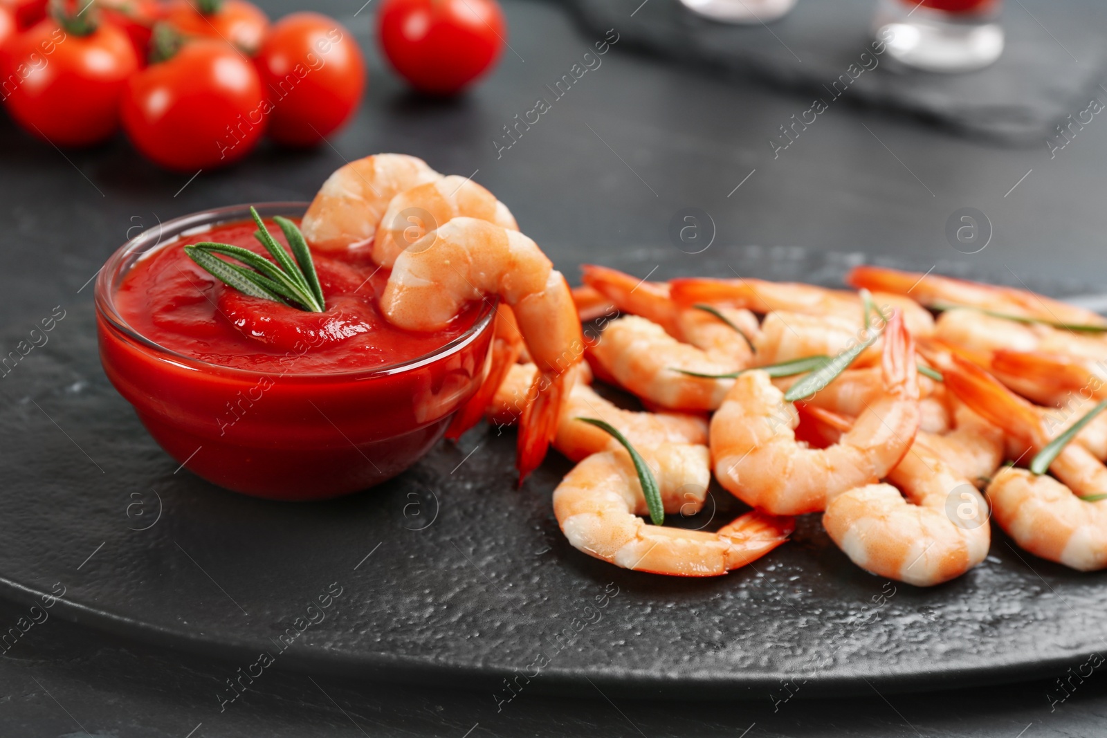 Photo of Delicious shrimp cocktail with tomato sauce served on black table