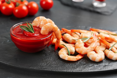 Photo of Delicious shrimp cocktail with tomato sauce served on black table