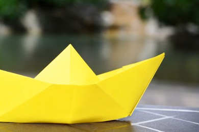 Photo of Beautiful yellow paper boat against blurred background, closeup