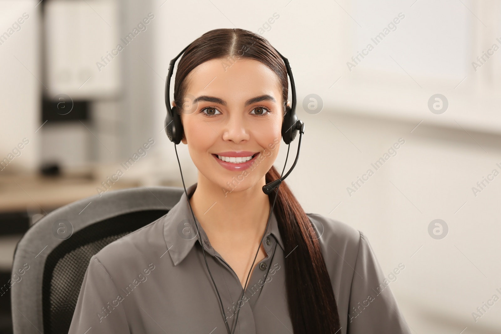 Photo of Hotline operator with headset working in office