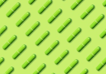 Image of Many tampons on light green background, flat lay 