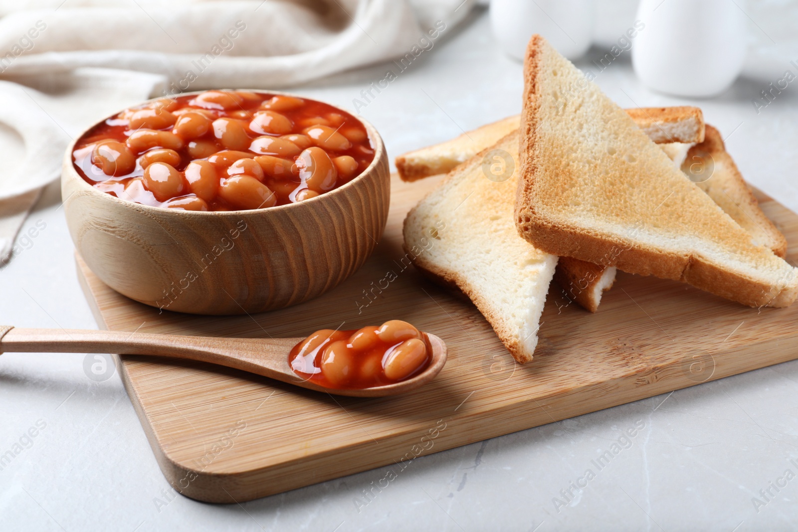 Photo of Toasts and delicious canned beans on white table