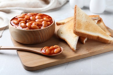 Toasts and delicious canned beans on white table