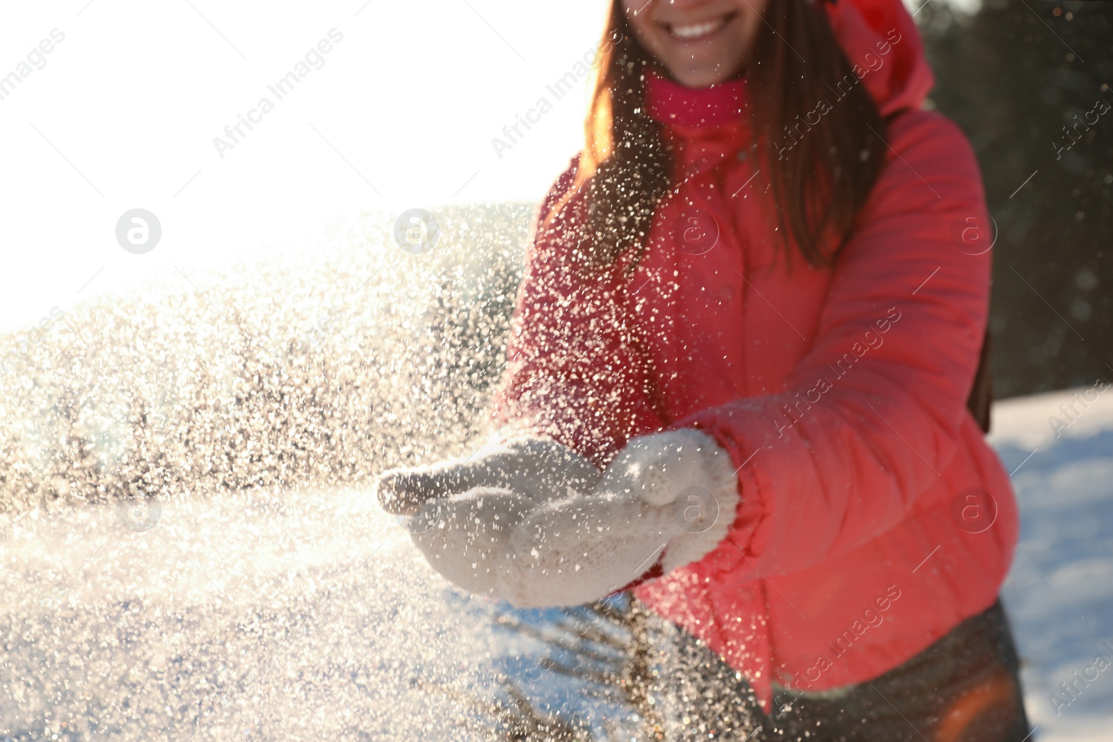 Photo of Young woman having fun outdoors on snowy winter day, closeup