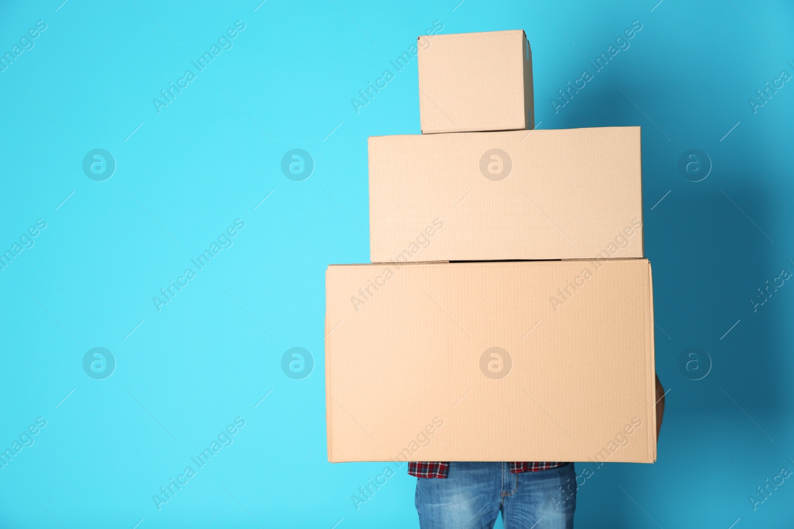 Photo of Man with moving boxes on color background. Space for text
