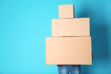 Man with moving boxes on color background. Space for text