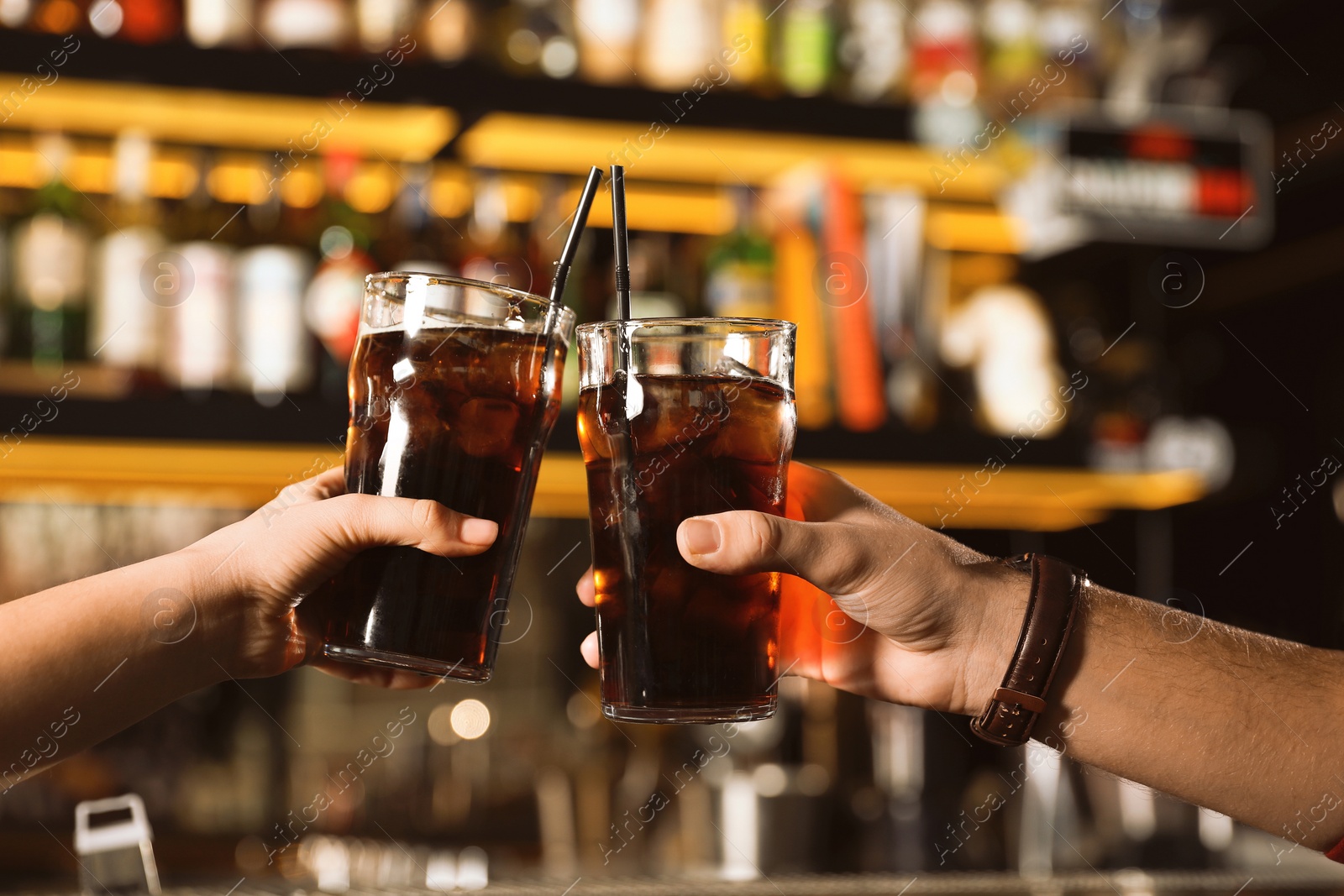 Photo of Young couple with glasses of cola in bar, closeup