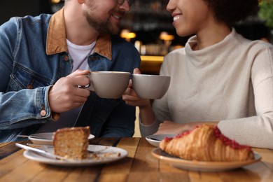 Photo of International relationships. Lovely couple having romantic date in cafe, closeup