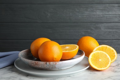 Photo of Plate with fresh juicy oranges on marble table