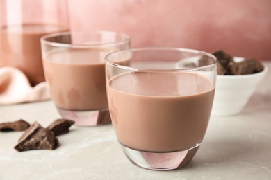 Photo of Glasses with tasty chocolate milk on table. Dairy drink